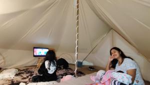 two women sitting on a bed in a tent at Glamping Xicotepec in Xicotepec de Juárez