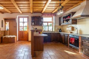 a large kitchen with wooden cabinets and a kitchen island at Balaton View From Almadi - Happy Rentals in Balatonalmádi
