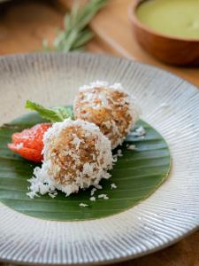un plato blanco con algo de comida en una hoja verde en The Bodhi Leaf Wellness Resort, en Saba