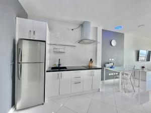 a kitchen with white cabinets and a stainless steel refrigerator at View Talay 6 by Pat 42 in Pattaya Central