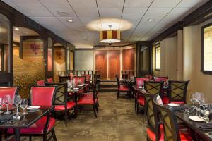 a dining room with tables and red chairs at The Raphael Hotel, Autograph Collection in Kansas City