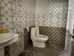 a bathroom with a white toilet and a sink at Nursery Guest House in Karachi