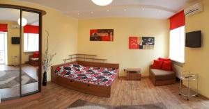a bedroom with a bed and a chair and a television at VIP studio in CENTER!!! in Mykolaiv