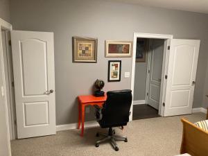 Cette chambre comprend un bureau, une chaise et une porte. dans l'établissement Matthew Manor, à Braselton
