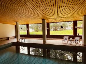 a room with a pool and two chairs and windows at CASA BLACK FOREST - Freudenstadt Kniebis in Freudenstadt