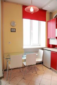 a kitchen with a glass table and white chairs at VIP studio in CENTER!!! in Mykolaiv
