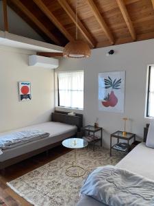 a living room with two beds and a table at AGASA residence in Fujieda