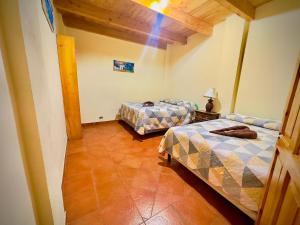 a room with two beds and a lamp in it at Hostal Dulces Sueños in Panajachel