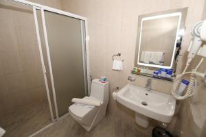 a bathroom with a toilet and a sink and a mirror at The Hotels Jojos in Nuwara Eliya +19 photos