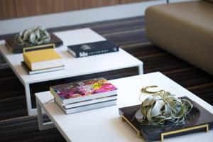 a room with two tables with books and plants on them at AC Hotel by Marriott Louisville Downtown in Louisville
