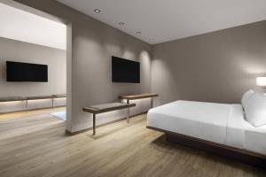 a bedroom with a bed and a desk and a tv at AC Hotel by Marriott Louisville Downtown in Louisville
