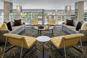 a lobby with couches and a table and chairs at AC Hotel by Marriott Louisville Downtown in Louisville