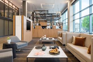 a living room with couches and a tv at AC Hotel by Marriott Louisville Downtown in Louisville