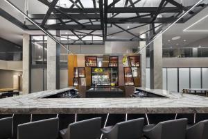 a lobby with a large marble counter and chairs at AC Hotel by Marriott Louisville Downtown in Louisville