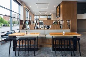two tables in a restaurant with a counter at AC Hotel by Marriott Louisville Downtown in Louisville