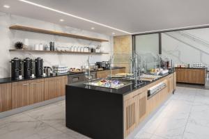 a large kitchen with a counter with food on it at AC Hotel by Marriott Louisville Downtown in Louisville