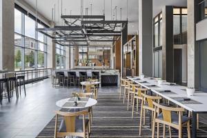 a restaurant with tables and chairs and windows at AC Hotel by Marriott Louisville Downtown in Louisville