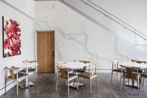 a dining room with tables and chairs and a painting at AC Hotel by Marriott Louisville Downtown in Louisville