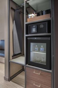 a small refrigerator with a microwave in a room at AC Hotel by Marriott Louisville Downtown in Louisville