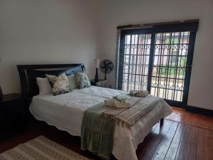 a bedroom with a bed and a large window at Jakess Place modern comfortable sunny 3-bedroom house in Kensington in Johannesburg