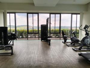 a gym with treadmills and ellipticals and a large window at HighView Homestay in Bandar Baru Bangi