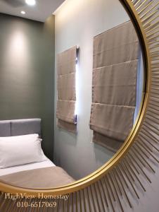 a mirror in a bedroom with a bed and towels at HighView Homestay in Bandar Baru Bangi +10 photos