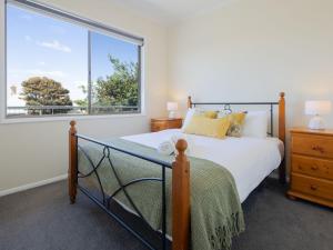ein Schlafzimmer mit einem Bett und einem großen Fenster in der Unterkunft North View in Warrnambool