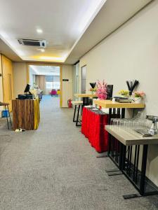 a room with desks and tables with flowers on them at Manhattan Hotel Ipoh in Ipoh