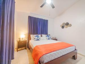 1 dormitorio con 1 cama con cortinas moradas y ventilador en 7br Massive Villa In Sosa - 2mins From Nightlife, en Sosúa 38 fotos más