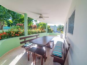 Un patio con mesa y sillas y flores. en 7br Massive Villa In Sosa - 2mins From Nightlife, en Sosúa