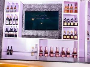 a bar with bottles of alcohol on a shelf at Ambience Hotel and Suite - Deluxe in Abuja