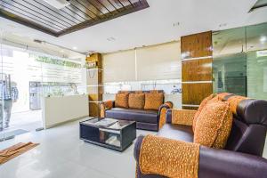 a living room with couches and a table at Hotel Tals Hitech - Nr Jubliee Enclave, Hitech CIty in Hyderabad