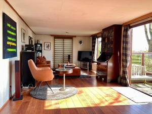 a living room with a couch and a chair at Tolles 2 Pers Haus König mit Hafenblick am Lauwersmeer in Anjum +27 photos