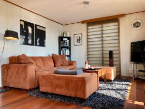 a living room with a couch and a table at Tolles 2 Pers Haus König mit Hafenblick am Lauwersmeer in Anjum