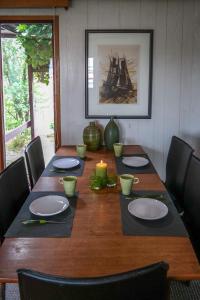 a long wooden table with chairs and plates and a candle at Tolles 2 Pers Haus König mit Hafenblick am Lauwersmeer in Anjum
