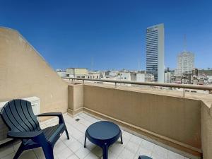 Un balcón con 2 sillas, una mesa y una ciudad en Spacious Studio in San Telmo with Balcony, Gym Pool, en Buenos Aires