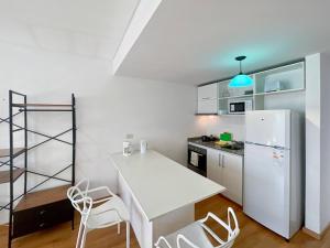 cocina con mesa blanca y nevera blanca en Spacious Studio in San Telmo with Balcony, Gym Pool, en Buenos Aires 9 fotos más