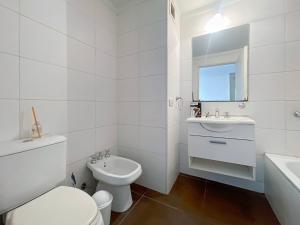 Un baño blanco con inodoro y lavabo. en Spacious Studio in San Telmo with Balcony, Gym Pool, en Buenos Aires