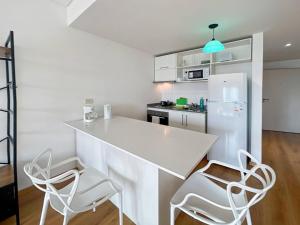 cocina con encimera blanca y 2 sillas en Spacious Studio in San Telmo with Balcony, Gym Pool, en Buenos Aires