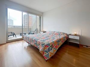 Un dormitorio con una cama y un escritorio y una gran ventana. en Spacious Studio in San Telmo with Balcony, Gym Pool, en Buenos Aires
