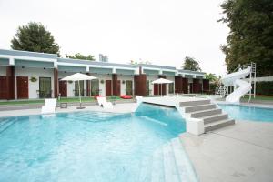 a swimming pool with a slide in front of a building at Big Alice Pool Villa Pattaya in Ban Hui Yai Muk