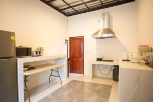 a kitchen with a refrigerator and a counter top at Big Alice Pool Villa Pattaya in Ban Hui Yai Muk