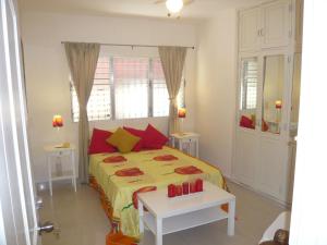 a bedroom with a bed with yellow and red pillows at Villa Los Almendros - 2 private pools tennis pickle ball in Baní +31 photos