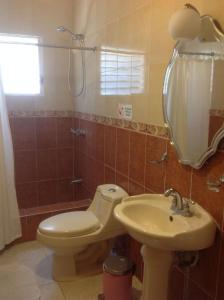 a bathroom with a toilet and a sink at Villa Los Almendros - 2 private pools tennis pickle ball in Baní