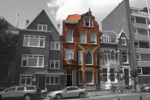 budynek z samochodami zaparkowanymi przed nim w obiekcie Bed & Breakfast Walenburg w Rotterdamie
