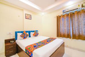 a bedroom with a large bed in a room at FabHotel Tals Hitech Nr Hitech City in Hyderabad +33 photos