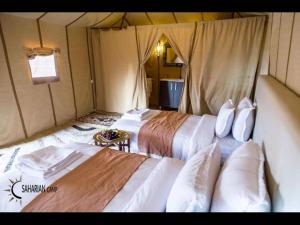 a room with two beds in a tent at Splendid desert Saharian Luxury Camp in quiet and idyllic sand dunes in Tisserdmine