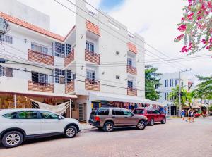 a group of cars parked in front of a building at 5th Avenue 3 people Balcony Apartment in Playa del Carmen