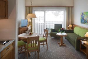 a living room with a couch and a table with chairs at Interest Vitalhotel - Partnerbetrieb von Oberstaufen PLUS in Oberstaufen