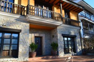 a stone building with a balcony and potted plants at Hotel The Island in La Isla